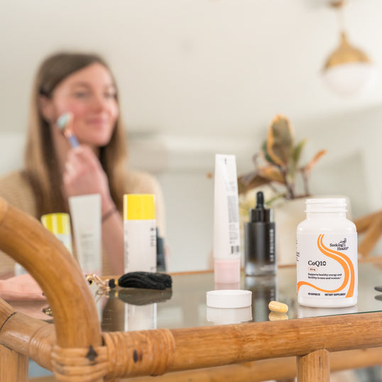 A woman next to a bottle of CoQ10