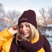 Person wearing a maroon beanie and scarf with 'Seeking Health' logo, standing outdoors in winter.