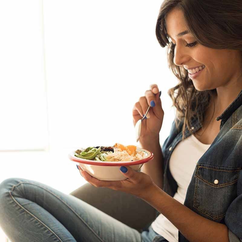 A woman eating a bowl of food